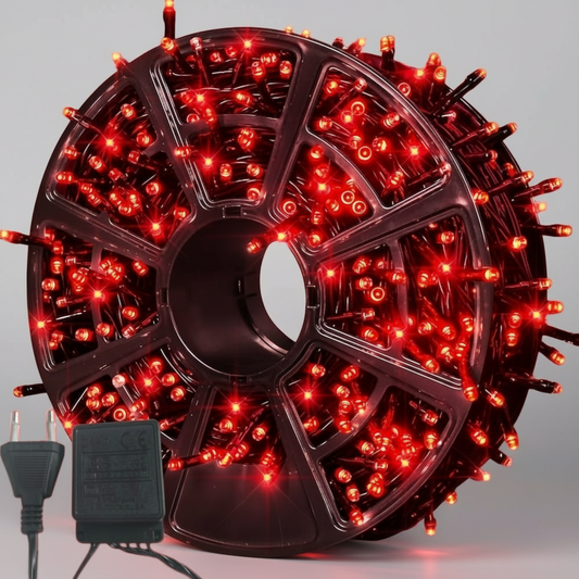 Spool of red LED string lights with power adapter on a white background